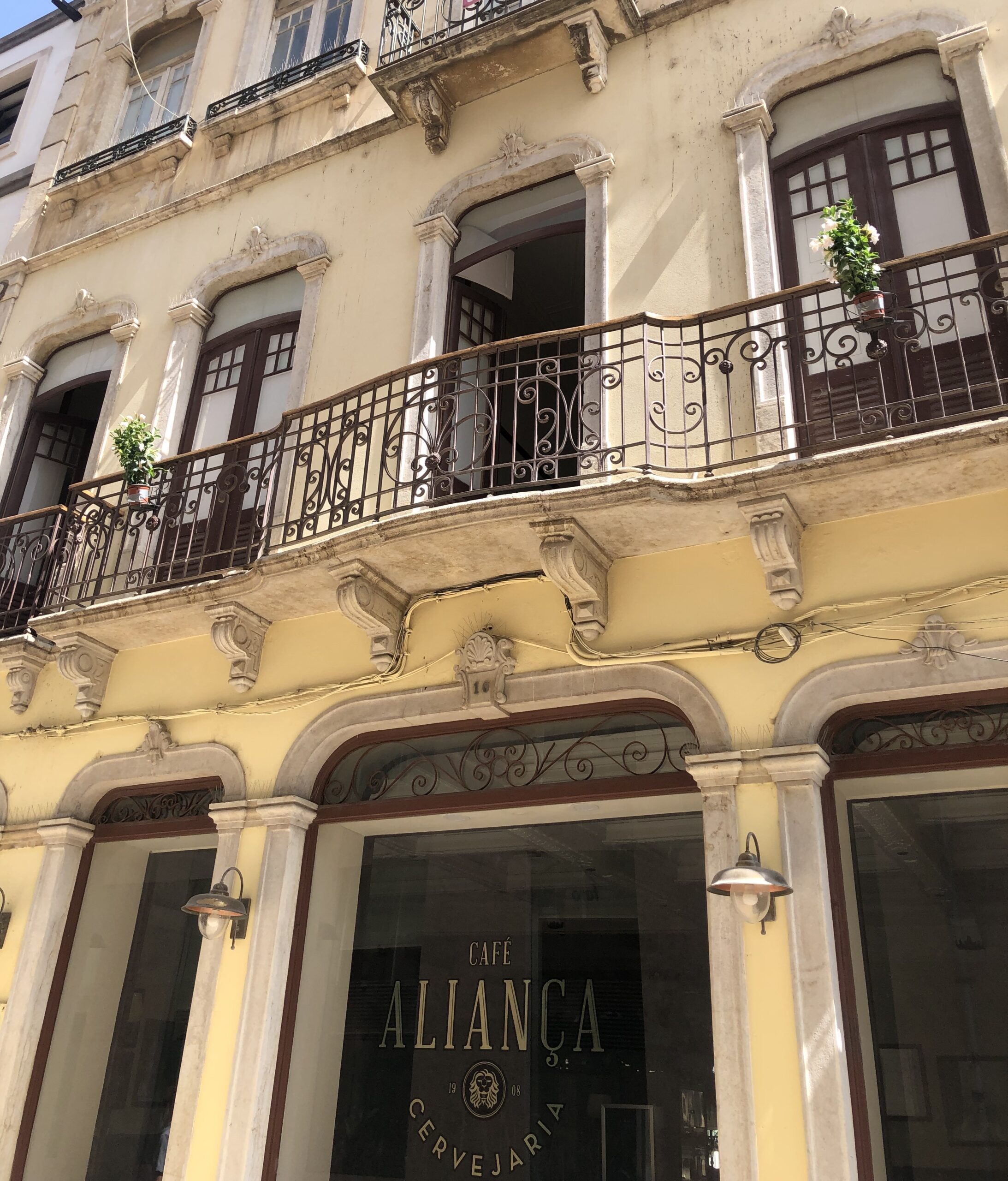 Historic building facade with ornate balcony and large windows.