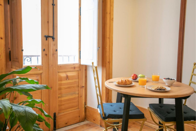 Cozy dining area with wooden table and natural light from large window.